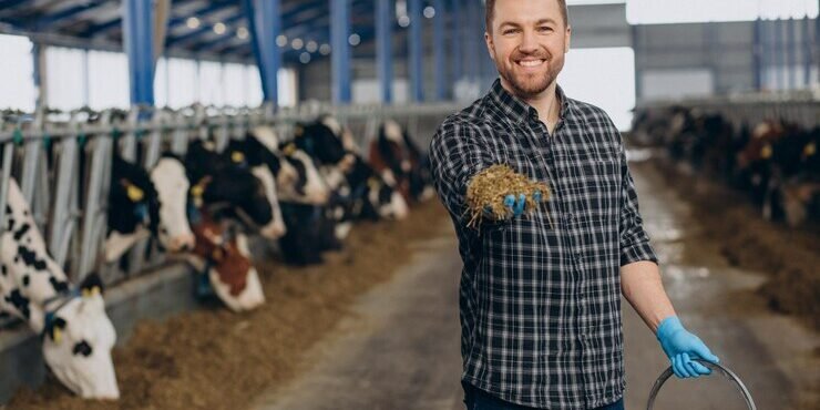 agricultor-no-estabulo-alimentando-vacas-na-fazenda_1303-30808