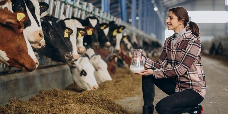 jovem-de-pe-com-jarro-de-leite-no-estabulo_1303-30971