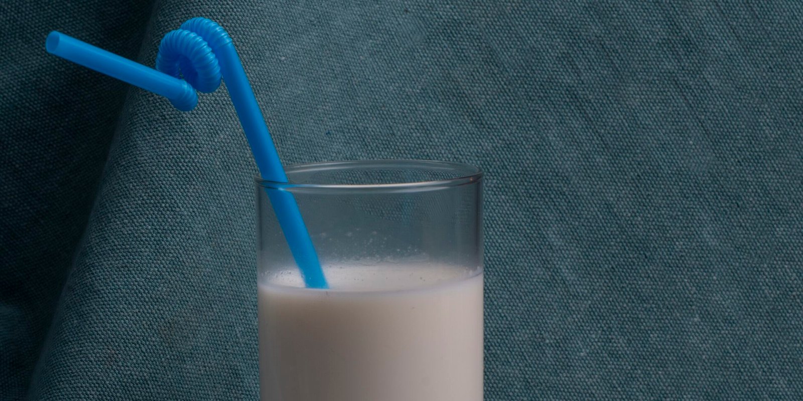 side view of gingerbread served with a glass of milk on blue background