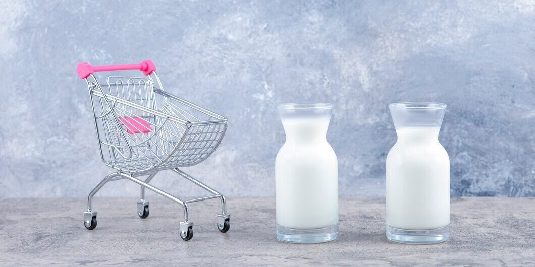 um-pequeno-carrinho-rosa-vazio-com-jarras-de-vidro-com-leite-fresco_114579-36672
