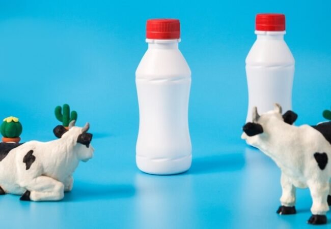 garrafas-de-leite-de-plastico-vacas-de-brinquedo-e-nuvens_116380-39